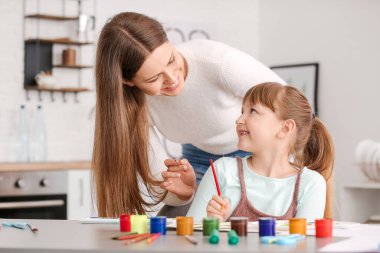 Çizim öğretmeni evde küçük bir kıza özel sanat dersleri veriyor.