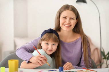 Çizim öğretmeni evde küçük bir kıza özel sanat dersleri veriyor.