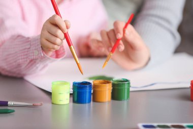 Çizim öğretmeni, evde küçük bir kıza özel sanat dersleri veriyor, yakın plan.