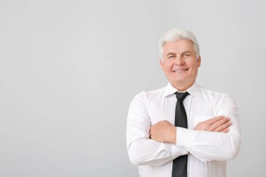 Gri arka planda yakışıklı kıdemli işadamının portresi