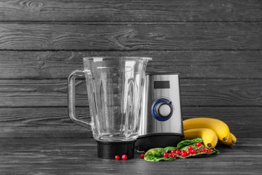 Modern blender ve koyu ahşap zemin üzerindeki ürünler