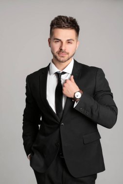 Gri arka planda yakışıklı genç iş adamının portresi