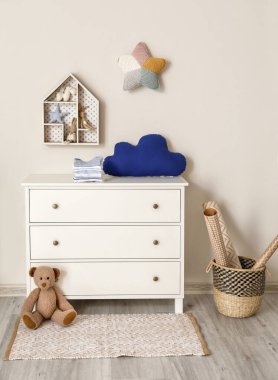 Çocuk odasında giysi ve oyuncakla dolu çekmeceler.