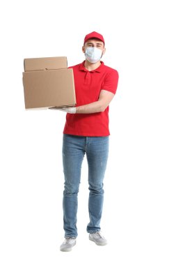 Tıbbi maskeli bir erkek kurye ve beyaz arka planda kutuları var.
