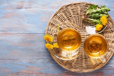 Sağlıklı karahindiba çayı ve renkli ahşap arka plan.