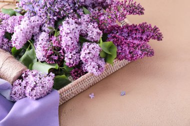 Masada güzel leylak çiçekleri olan hasır tepsi