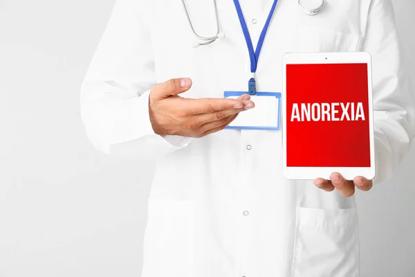Male Doctor Holding Tablet Computer Word Anorexia Screen Light Background — Stock Photo, Image