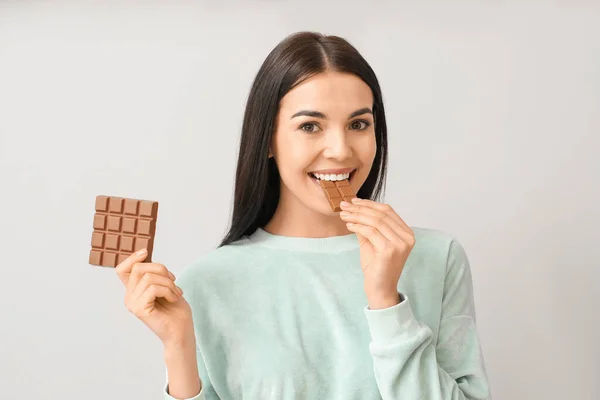 Beautiful Young Woman Tasty Chocolate Light Background — Stock Photo, Image