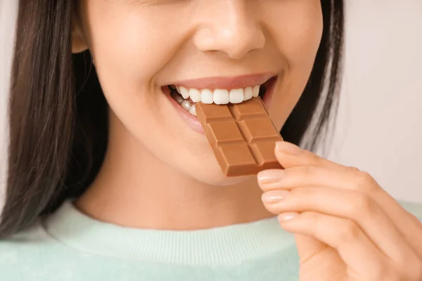 Beautiful Young Woman Eating Tasty Chocolate Light Background Closeup — Stock Photo, Image