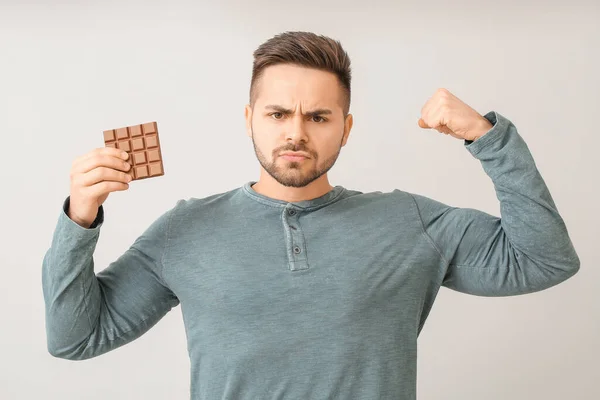 Hafif Arka Planda Lezzetli Çikolataları Olan Güçlü Genç Bir Adam — Stok fotoğraf