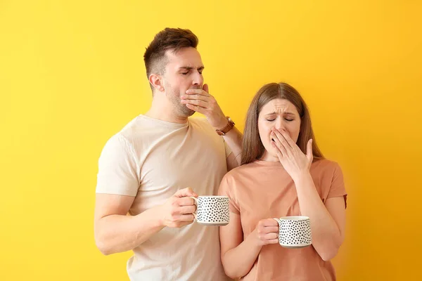 Pareja Joven Soñolienta Con Café Sobre Fondo Color — Foto de Stock