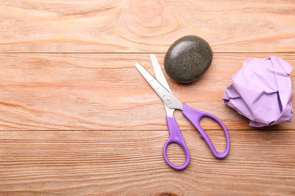 Scissors, rock and paper on wooden background