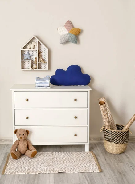 Chest of drawers with clothes and toys in children\'s room