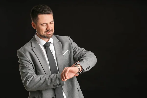 Portret Van Knappe Zakenman Kijkend Zijn Horloge Donkere Achtergrond — Stockfoto