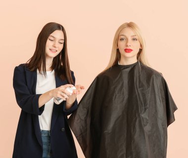 Genç kuaför renk arka planına karşı müşteriyle birlikte çalışıyor