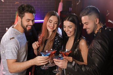 Gece kulübünde kokteyl içen mutlu gençler.