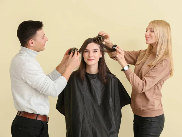 在彩色背景下与客户合作的年轻理发师 — 图库照片