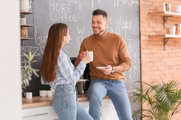 İş arkadaşları mutfakta kahve içiyor.