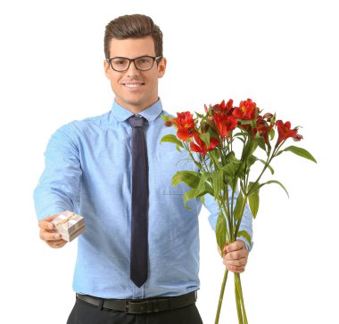 Çiçek buketi olan yakışıklı bir adam ve beyaz arka planda bir hediye.