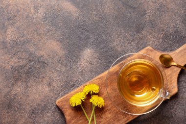 Gri arkaplanda bir fincan sağlıklı karahindiba çayı.