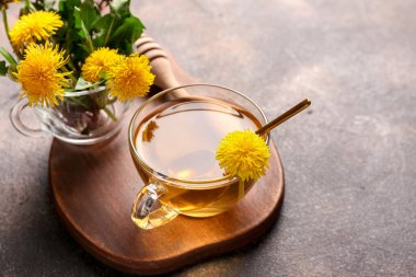 Gri arkaplanda bir fincan sağlıklı karahindiba çayı.