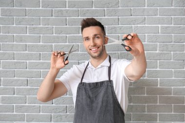 Tuğla grisi arka planda erkek kuaför