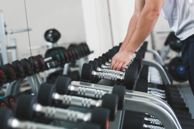 Spor salonunda Dambıl ile sportif genç adam eğitim