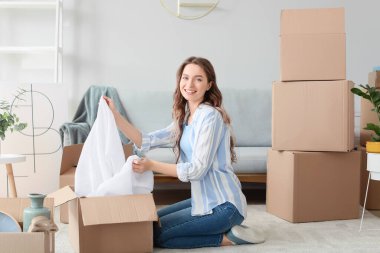 Yeni evinde kutuları açan genç bir kadın.
