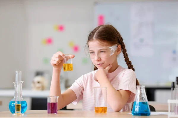 Little girl at chemistry lesson in classroom