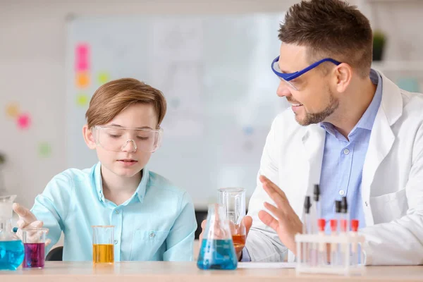 Teacher and pupil at chemistry lesson in classroom