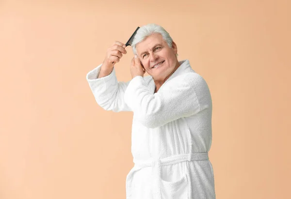 Mature Man Bathrobe Combing His Hair Color Background — Stock Photo, Image