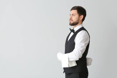 Gri arka planda yakışıklı erkek garson.