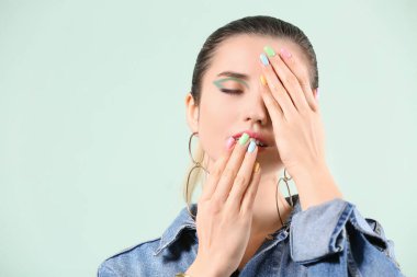 Renkli arka planda güzel manikürlü genç bir kadın.