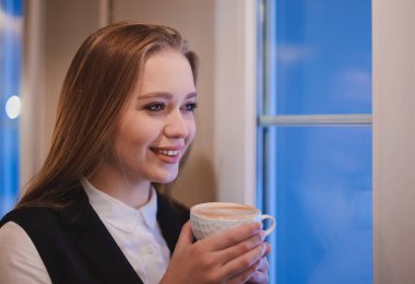 Kafede kahve içen genç iş kadını.