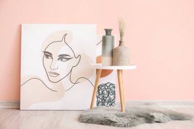 Odanın içinde masa ve renkli duvarların yanında vazolar var.