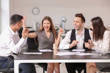 İş adamlarından oluşan bir ekip ofiste Jenga oynuyor.