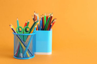 Renk arkaplanı üzerinde kırtasiye malzemesi olan tutucular