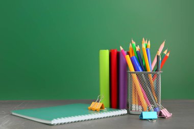 Sınıftaki masanın üzerinde kırtasiye malzemesi olan tutucu