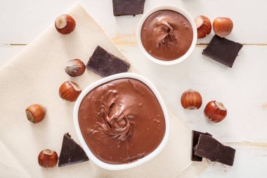 Lezzetli çikolata ezmeli kaseler ve masada fındıklar