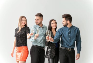 Gri arka planda şampanya kadehleri olan mutlu insanlar.