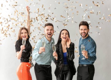 Gri arka planda şampanya kadehleri olan mutlu insanlar.