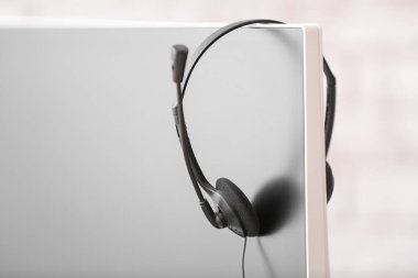 Kulaklıklar ofisteki teknik destek ajanının monitöründe asılı.