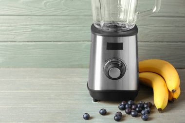 Ahşap zemin üzerinde modern blender ve ürünler