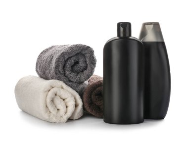 Beyaz arka planda duş jelleri ve havlular