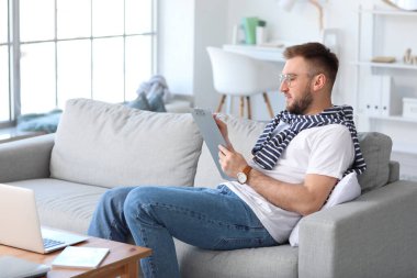 Genç adam evde çalışıyor.