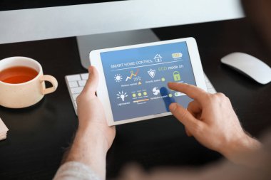 Akıllı ev otomasyonu uygulaması kullanan adam