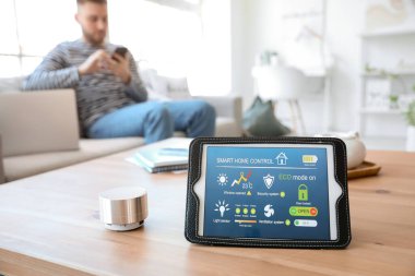Akıllı ev otomasyonu uygulamalı tablet bilgisayar ve masadaki yardımcı aygıt