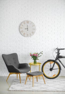 Rahat koltuğu, masası ve bisikleti olan modern oturma odasının içinde.