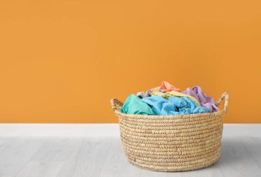 Çamaşır sepetinin yanında renkli duvar var.