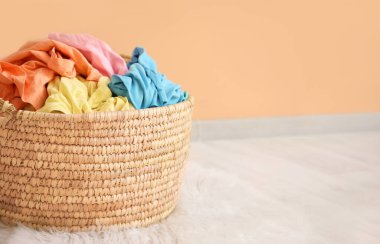 Çamaşır sepetinin yanında renkli duvar var.